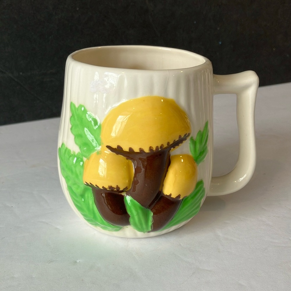 Preowned mug. Off white with brown and yellow mushrooms on front and back.